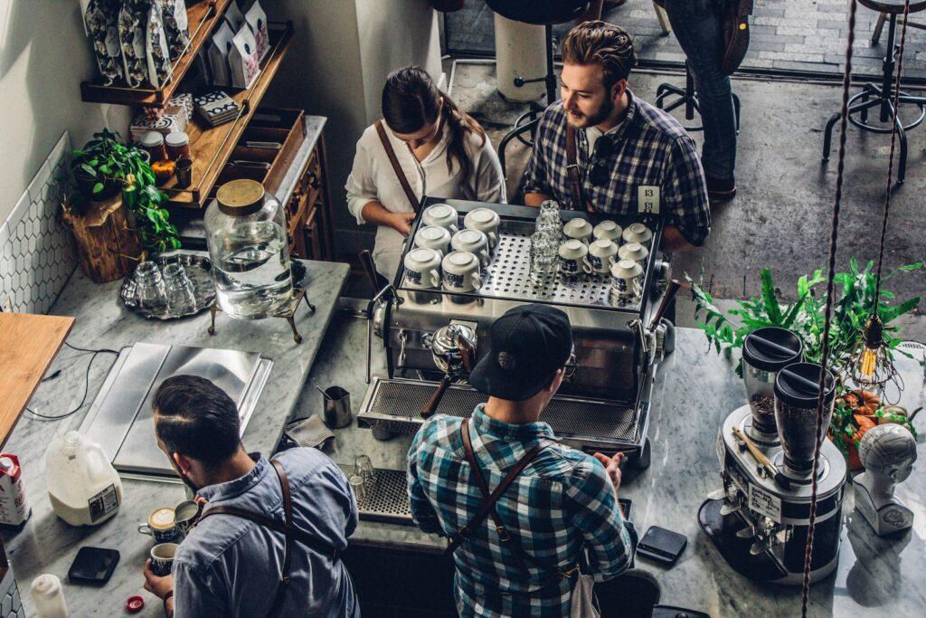 A diverse group of people gathered around a coffee machine