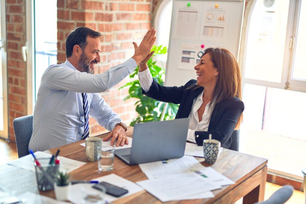 Two business professionals high five each other